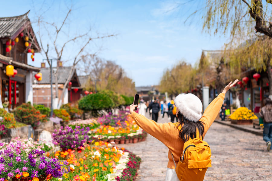 Mujer con gorro de lana y levantando los brazos como de felicidad, de turismo en China