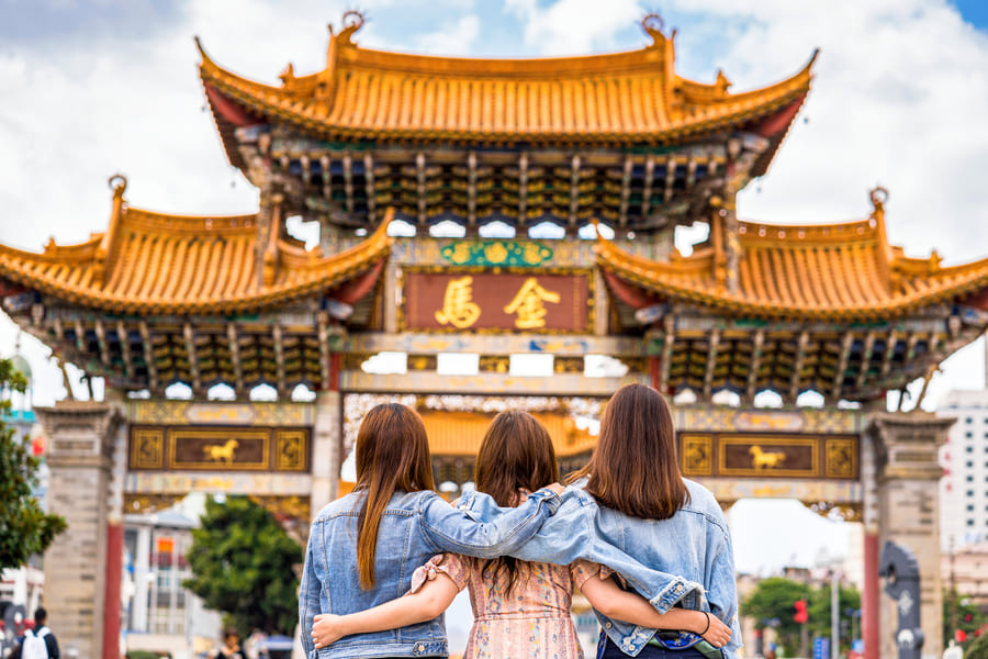 Vacaciones, tres chicas dando la espalda están viendo un monumento de China